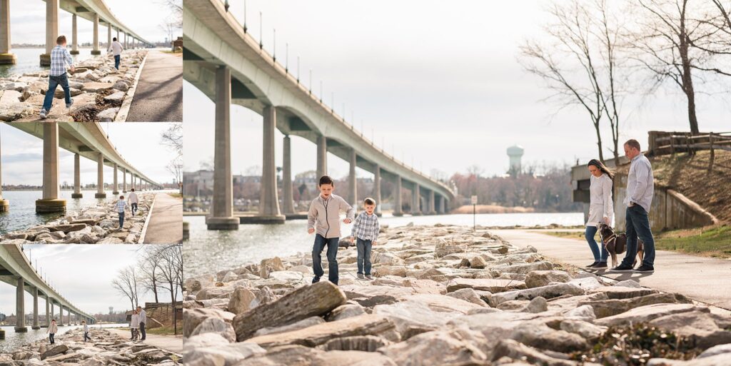two boys playing on rocks by bridge